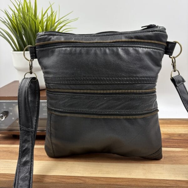 Sac à main de cuir noir avec détails zippés