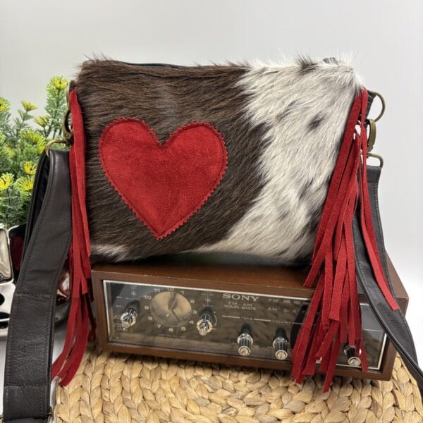 Sac à bandoulière en cuir recyclé brun et franges rouges de style western bohème avec détail de coeur et fourrure de vache